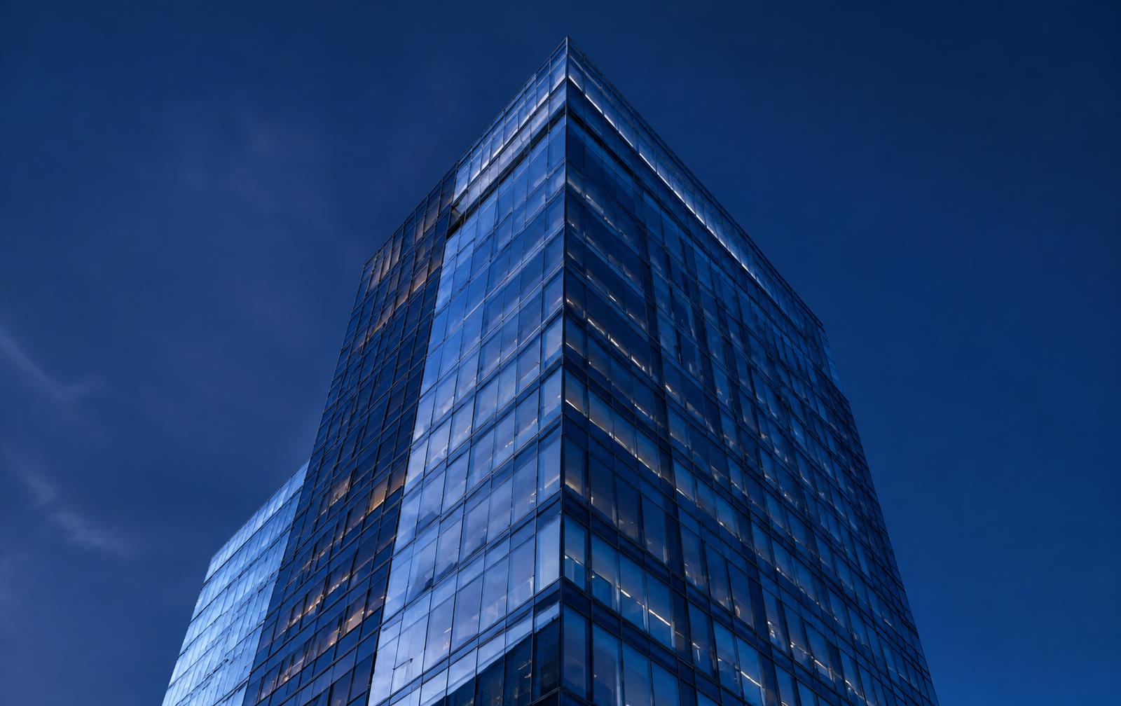 Glass commercial office tower at dusk
